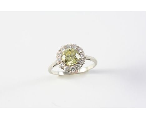 A YELLOW DIAMOND AND DIAMOND CLUSTER RING the circular-cut yellow diamond is set within a surround of circular-cut diamonds, 