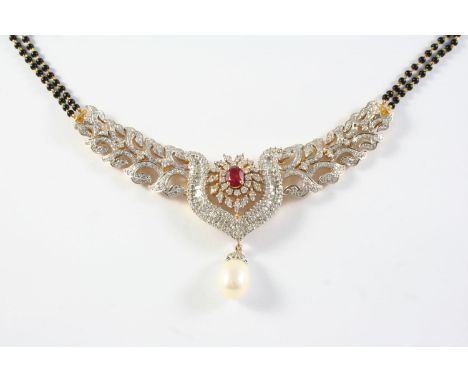 A DIAMOND AND RUBY NECKLACE the oval-shaped ruby is set within a scolling foliate surround of baguette-cut and circular-cut d