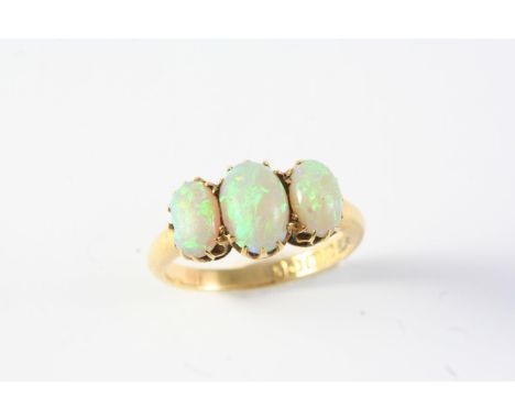 AN OPAL THREE STONE RING the three graduated oval solid white opals are set in 18ct gold, hallmarked for Birmingham 1909. Wit
