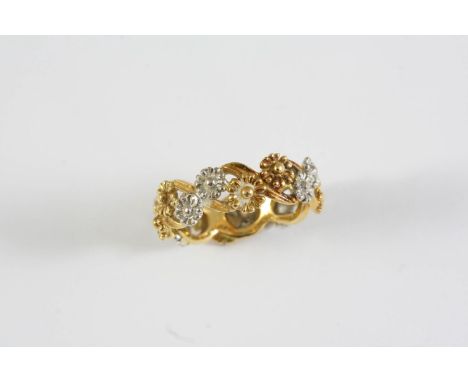 AN 18CT TWO COLOUR GOLD BAND RING formed with white and yellow gold flowerheads. Size R 1/2