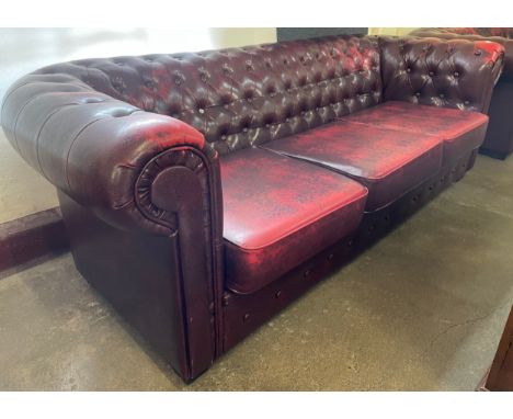 An oxblood faux red leather Chesterfield sofa 