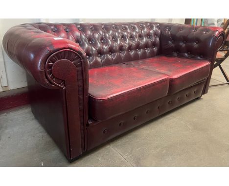 An oxblood faux red leather Chesterfield sofa 