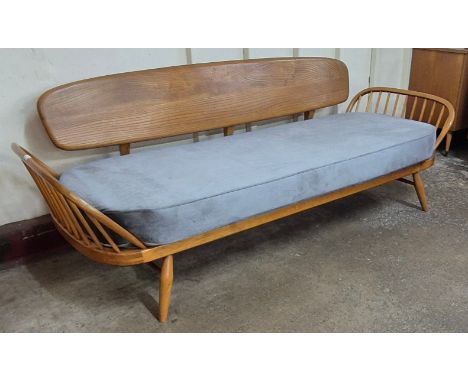 An Ercol Blonde elm and beech 355 model studio couch. Please note this lot is being sold as a work of art. It may not comply 