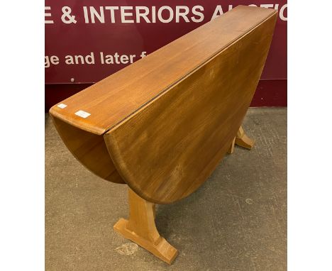 An Ercol Blonde elm and beech Windsor drop leaf table 