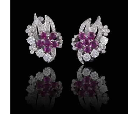 A PAIR OF RUBY AND DIAMOND EARCLIPS, CIRCA 1950Of stylised foliate design, each set to the centre with six circular-cut rubie