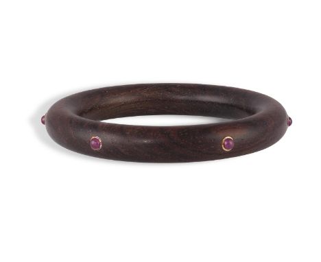 A WOOD AND RUBY BANGLE, BY PAUL BINDERThe wooden bangle set with round-shaped ruby cabochons, bangle inner diameter 6cm, with
