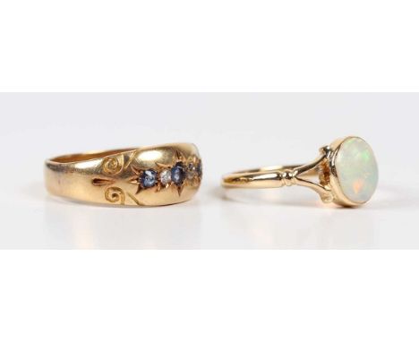 A gold ring, collet set with an oval opal between split shoulders, detailed ‘18ct’, weight 2.4g, ring size approx L1/2, and a