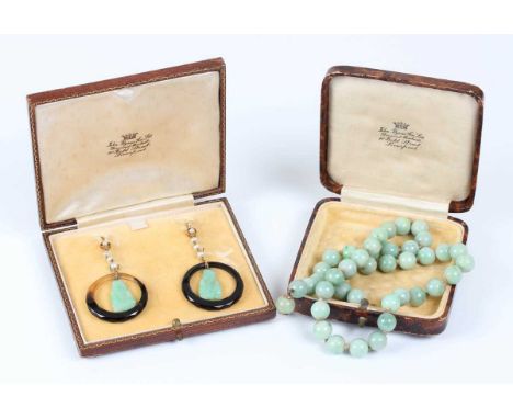 A pair of gold, jade, onyx and seed pearl pendant earrings, each mounted with a carved jade Buddha within an onyx circular op