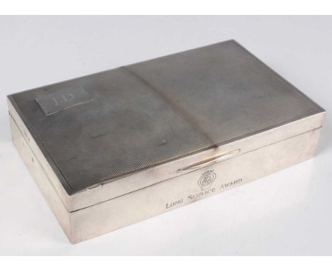 An Elizabeth II silver rectangular cigarette box, the engine turned hinged lid initial engraved, the front engraved with the 