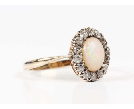 A gold, opal and diamond oval cluster ring, the oval opal mounted within a surround of old cut diamonds, unmarked, weight 2.3