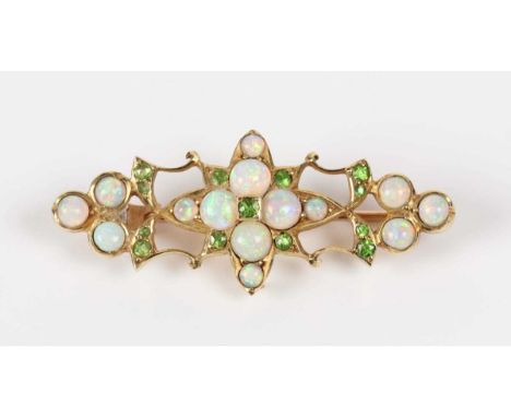 An Edwardian gold, opal and green garnet brooch in an openwork design, unmarked, weight 4.3g, width 4cm, with a case.