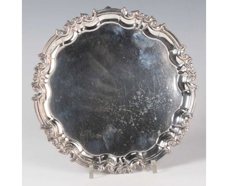 A George V silver circular salver with raised piecrust and scroll rim, on scroll feet, Sheffield 1918 by William Hutton &amp;