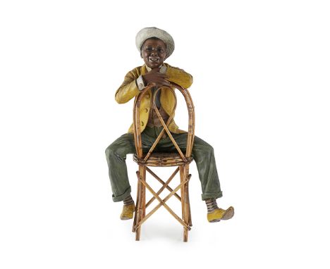 FRIEDRICH GOLDSCHEIDER (1845-1897) FIGURE OF A BOY, CIRCA 1895 model 1368, painted terracotta, bamboo and rattan chair, stamp