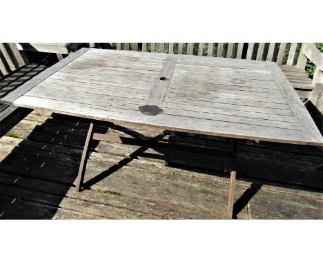 A good quality weathered teak garden table with slatted top and folding x shaped frame, 155cm x 95cm to seat six 