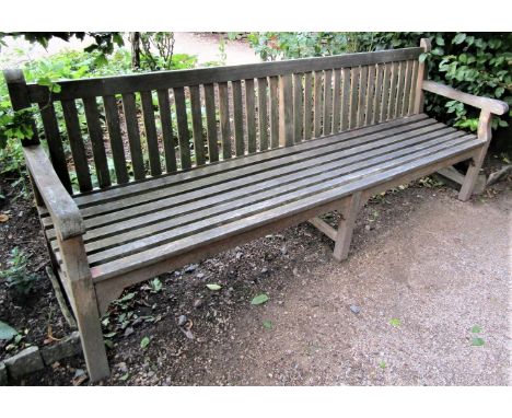 A weathered teak wood garden bench, 240cm wide 