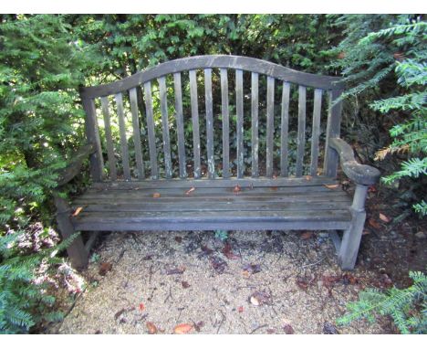 A weathered teak wood garden bench, with scrolled arms and slatted back, 100cm wide 