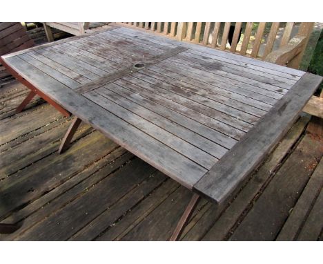 A good quality weathered teak garden table with slatted top and folding x shaped frame, 155cm x 95cm to seat six 