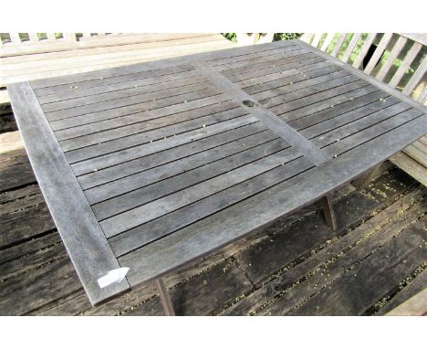 A good quality weathered teak garden table with slatted top and folding x shaped frame, 155cm x 95cm to seat six 