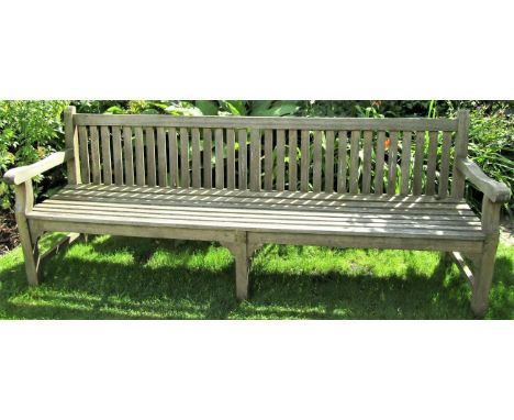 A weathered teak wood garden bench, 240cm wide 