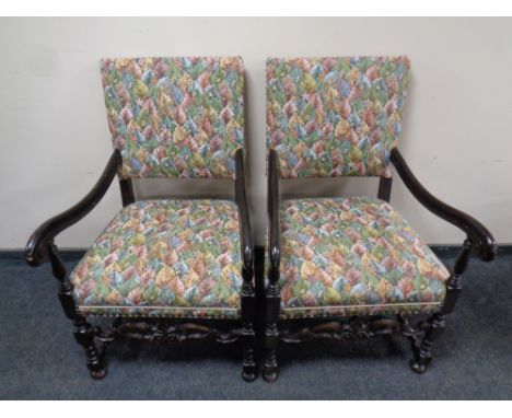 A pair of carved oak early 20th century scroll arm armchairs in a tapestry fabric 