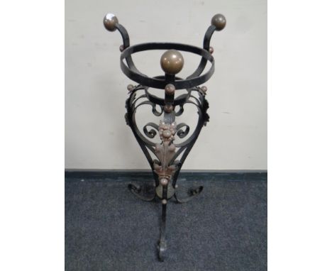 An antique wrought iron and copper oil lamp stand 