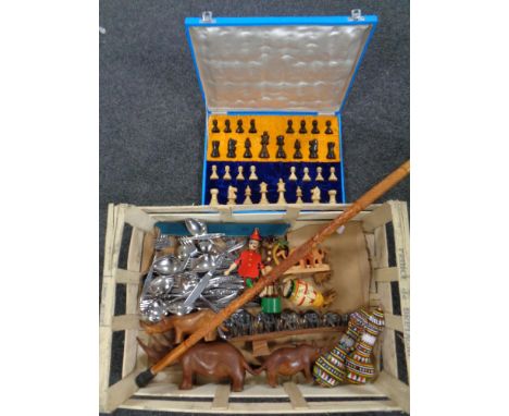 A box of wooden pieces - cased chess set, animal ornaments, walking stick, two beaded flasks, stainless steel cutlery 