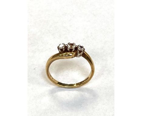 A yellow gold ring set with three diamonds 