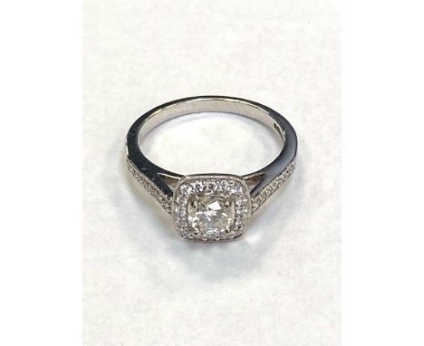 An 18ct white gold diamond halo style ring, with diamond shoulders, size M.