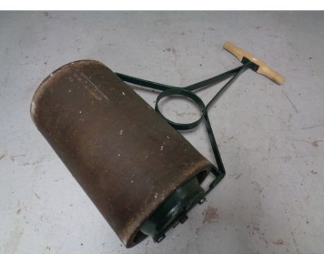 A vintage cast iron and wooden handled garden roller 
