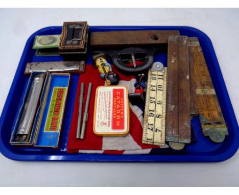 A tray of Hohner mouth organ, miniature cash box, Robertson's figures, folding wooden rules, Union Jack flag etc 