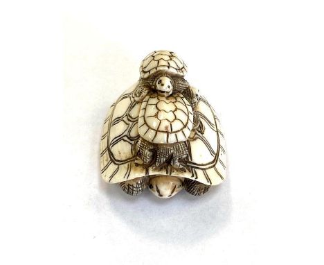 A Japanese carved netsuke depicting a turtle family, length 42 mm.