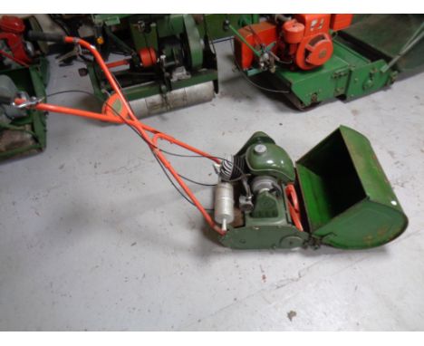 A vintage Qualcast 4 stroke Commodore petrol lawn mower with grass box and roller 