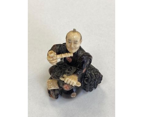 A carved Ivory netsuke depicting a Gentleman with pipe, height 45 mm.