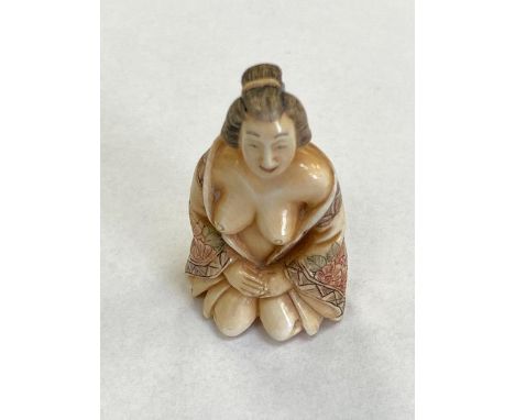 A carved Japanese netsuke nude wearing a gown, height 45 mm.