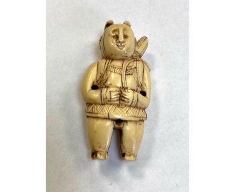 A Japanese carved netsuke modelled as a figure wearing traditional dress, height 53 mm.
