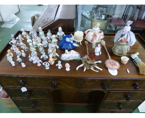 A large collection of Edwardian German and other hand-painted porcelain pincushion half dolls of varying sizes, including fou