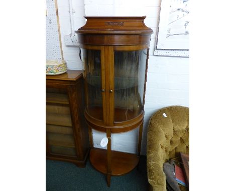 An unusual demi-lune red walnut china display cabinet raised high on three tapering square legs united by a low tier, the cab