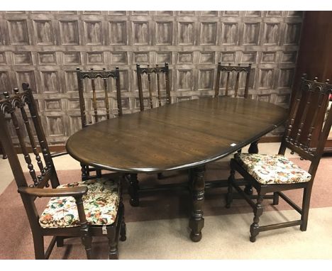 ERCOL STAINED OAK DINING SUITEto comprise an extending table and six chairs, the oval table top on four baluster turned legs 