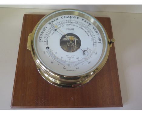 A Stockburger ships barometer in circular brass case on wooden mount 