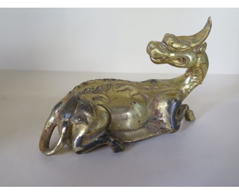 A Chinese gilt bronze recumbent dragon, 10cm tall x 15cm - good condition - some wear to gilt 