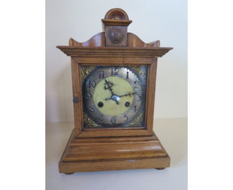 An oak mantle clock striking on a gong 