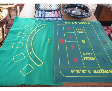 A Bakelite roulette wheel by Caro of Paris, gaming chips, dice and playing cards with baize in an aluminium case and a roulet