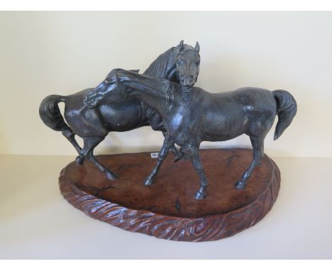 A bronze sculpture of horses, entwined raised on a wooden plinth base - Width 57cm x Depth 30cm x Height 38cm 