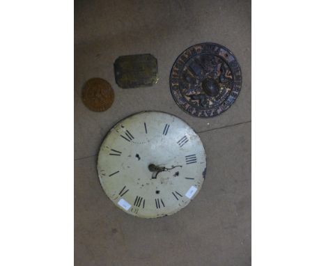 A clock dial and three safe plaques 