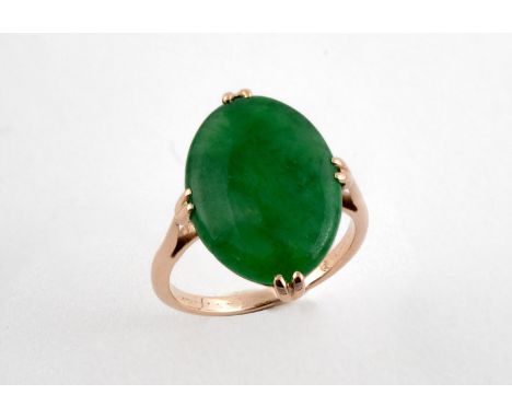 A JADE SINGLE STONE RING the oval-shaped jade is set in yellow gold. Size K