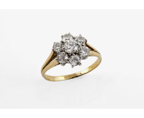 A DIAMOND CLUSTER RING the flowerhead design is set with seven circular-cut diamonds in 18ct yellow gold. Size M 1/2