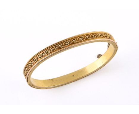 A GOLD HINGED BANGLE with embossed scroll decoration, 11.1 grams, internal measurements 4.5 x 5.5cm