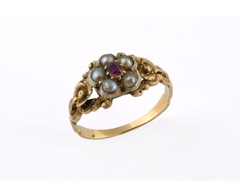 A VICTORIAN RUBY AND PEARL CLUSTER RING the oval-shaped ruby is set within a surround of half pearls, with foliate decoration