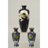 A CHINESE BLACK GROUND CLOISONNE VASE, 24cm high, together with a smaller pair of vases, (3).