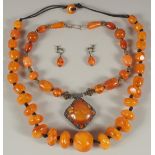 TWO AMBER RESIN BERBER NECKLACES AND A PAIR OF EARRINGS.